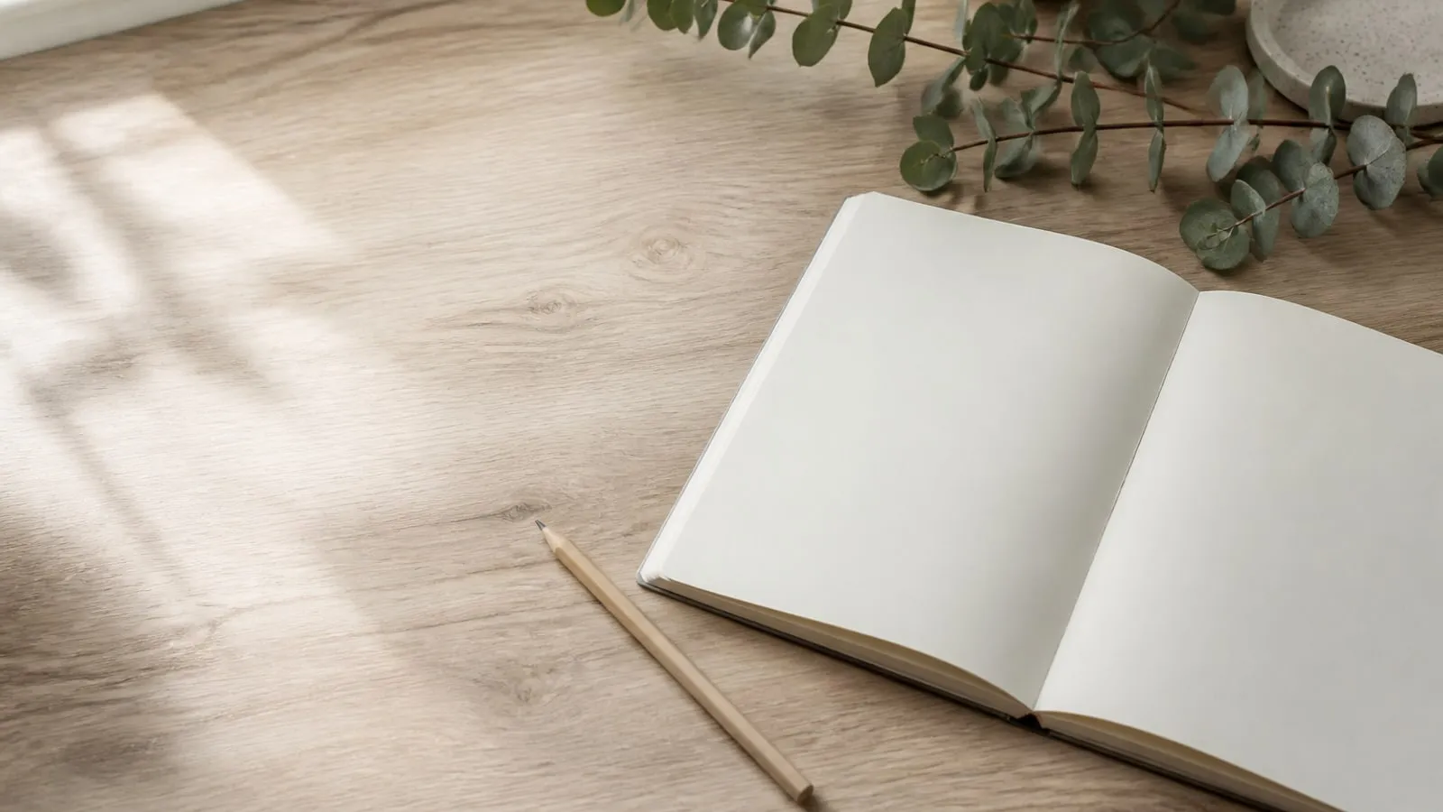 Carnet ouvert et crayon sur une table claire, dans une atmosphère calme